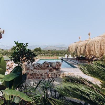 finca-ibizenko-style-poolbereich-sonnenliegen-sonnenschirme-mallorquin-landschaftsblick